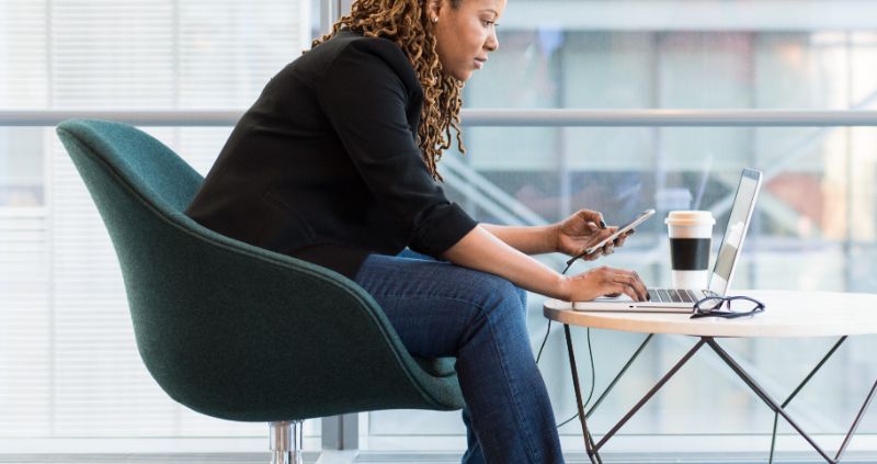 Can a chiropractor help with bad posture - A woman using a computer at a table with bad posture.